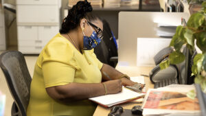 A Worker Writing Notes at Reception at Thewomenschoice